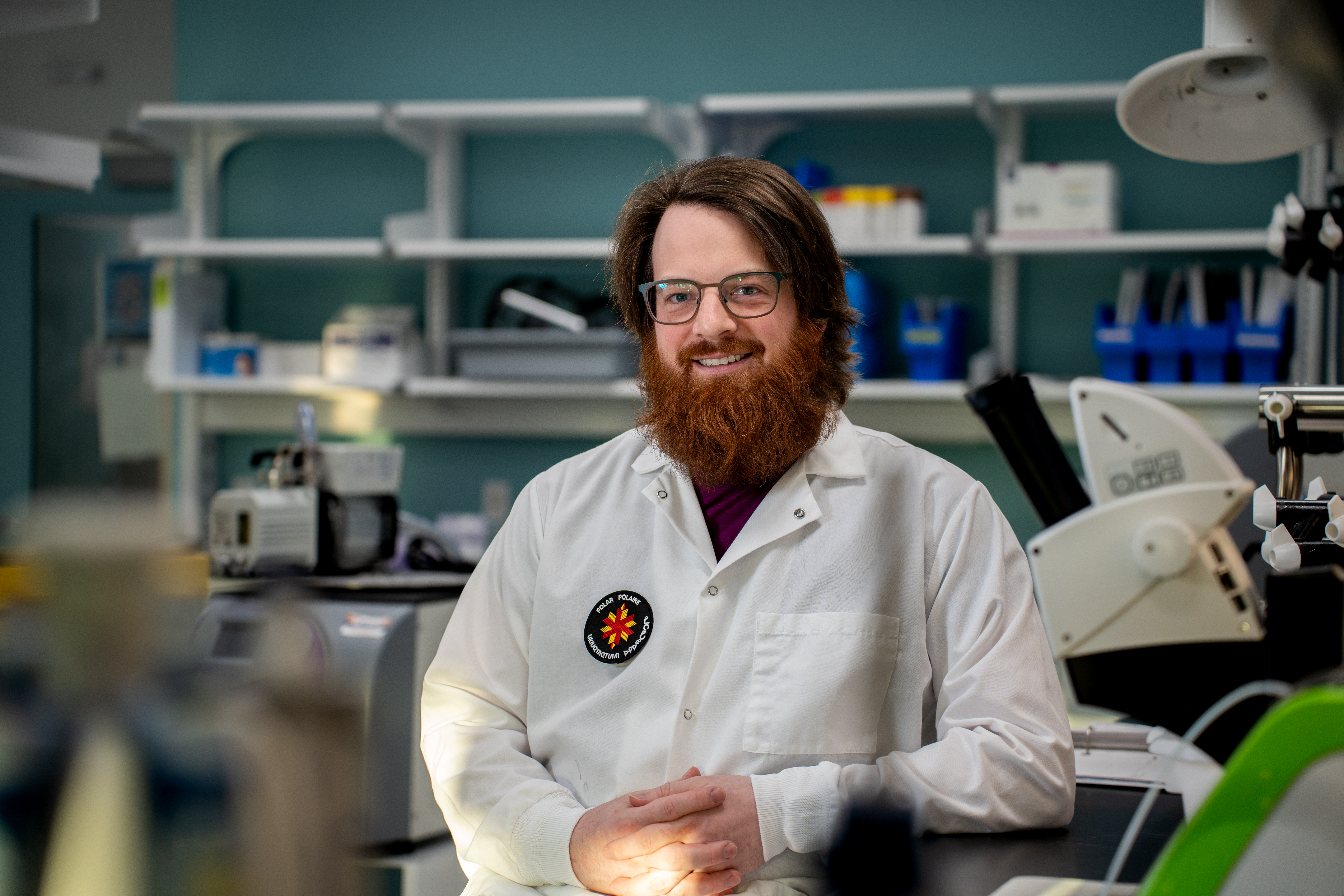 A smiling bearded man in a lab coat.